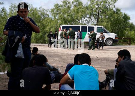 I migranti vengono trattenuti mentre vengono processati dalla pattuglia di confine degli Stati Uniti prima di prendere un autobus per un centro di detenzione il secondo giorno dell’attuazione della “credibile Fear and Asylum Processing Interim Final Rule”, il 1 giugno 2022 a la Joya, Texas, USA. La regola prevede che i casi che possono beneficiare dell'asilo siano accelerati in mesi anziché in anni, nel tentativo di alleviare il ritardo dei casi in tribunale. Il titolo 42, il mandato dell’era Trump che era stato fissato per impedire ai migranti di entrare negli Stati Uniti, doveva scadere il 23 maggio ma era stato bloccato da una causa intentata da diversi stati che citavano che la mossa t Foto Stock