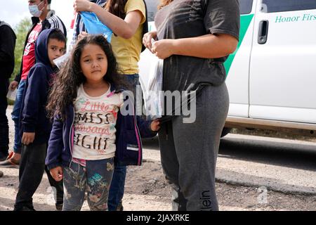 I migranti vengono trattenuti mentre vengono processati dalla pattuglia di confine degli Stati Uniti prima di prendere un autobus per un centro di detenzione il secondo giorno dell’attuazione della “credibile Fear and Asylum Processing Interim Final Rule”, il 1 giugno 2022 a la Joya, Texas, USA. La regola prevede che i casi che possono beneficiare dell'asilo siano accelerati in mesi anziché in anni, nel tentativo di alleviare il ritardo dei casi in tribunale. Il titolo 42, il mandato dell’era Trump che era stato fissato per impedire ai migranti di entrare negli Stati Uniti, doveva scadere il 23 maggio ma era stato bloccato da una causa intentata da diversi stati che citavano che la mossa t Foto Stock