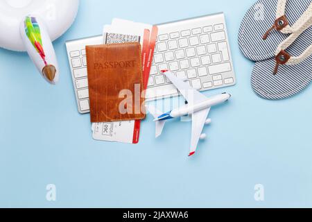 Concetto di viaggio e vacanza. Accessori e oggetti viaggio. Passaporto con biglietti, tastiera e giocattolo dell'aeroplano. Vista dall'alto, disposizione piatta Foto Stock