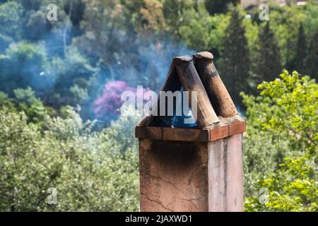 Primo piano di un camino fumante su sfondo verde Foto Stock