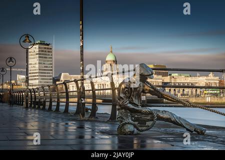 Statua in bronzo 'The Linesman' di Dony McManus con paesaggio urbano di Dublino sullo sfondo, fiume Liffey, Dublino, Irlanda Foto Stock