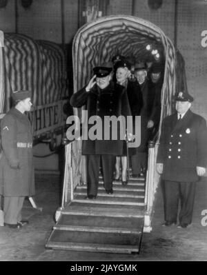 Churchill arriva a bordo della regina Elisabetta : Winston Churchill, ex primo ministro britannico, saluta con un sorriso mentre si sposta da una passerella dopo essere arrivato qui oggi a bordo della linea regina Elisabetta. Dietro di lui c'è la signora Churchill. Gennaio 12, 1946. (Foto di AP Wirephoto). Foto Stock