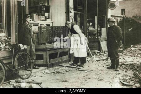 Procedendo su -- Un negoziante di Londra nell'area del molo di East End mette in su un segno 'di affari come usuale' 18 settembre dopo che il suo negozio era stato danneggiato dai bombardamenti. Gennaio 10, 1940. (Foto di stampa associata). Foto Stock