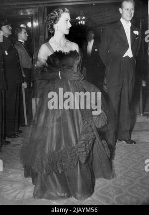 Princess in Black for Royal Show -- guardando bello in un nero, pieno-skirted abito da sera e indossare orecchini, è la Principessa Margaret, che si vede arrivare al Teatro Empire, Leicester Square, per il Royal Film Performance. Vicino alla Principessa sorge il Duca di Edimburgo, che scortò la Regina allo spettacolo. Ottobre 28, 1952. (Foto di Rota/AP) Foto Stock