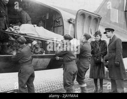 Duchessa di Kent visita West Country Aerodrome -- la duchessa di Kent (a destra) guarda un caso barella che viene estratto da un aereo ospedaliero. La duchessa del Kent visitò un aerodromo del West Country dove assistette all'arrivo di soldati feriti, che erano stati volati dal Teatro belga della guerra. Dal D-Day, R.A.F. Transport Command ha volato 50.000 vittime negli ospedali in Inghilterra. Dicembre 8, 1944. Foto Stock