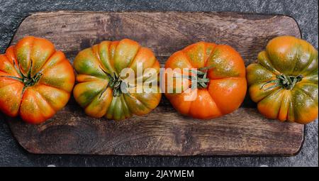 Un gruppo di grossi pomodori Costoluto su sfondo ligneo Foto Stock