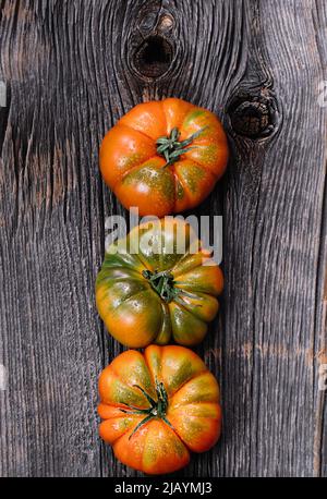 Un gruppo di grossi pomodori Costoluto su sfondo ligneo Foto Stock