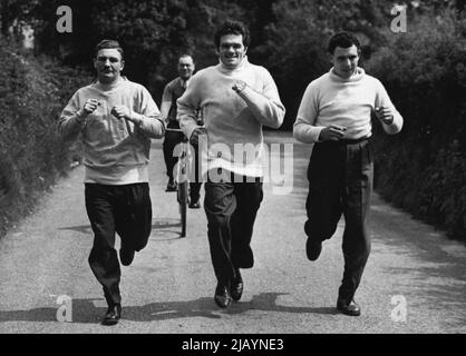 Mills inizia l'allenamento per la lotta Woodcock. Mulini e due dei suoi colleghi del campo di addestramento sulla strada vicino al suo quartiere oggi. Sono Ken Shaw, il campione scozzese di pesi massimi (a sinistra) e partner di sparring Johnny Williams, del Galles. Freddie Mills, campione mondiale di pesi da crociera, ha iniziato ad allenarsi oggi presso un osteria ai piedi di Bexhill, un luogo di bellezza Surrey, in preparazione alla sua battaglia di campionato di pesi massimi britannici con Bruce Woodcock, l'attuale chantion di pesi massimi. Maggio 12, 1949. (Foto di Fox). Foto Stock