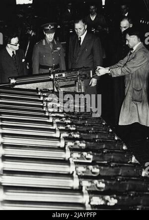 Il re visita i lavoratori della domenica alla fabbrica di armi -- il re, con il sig. Morrison che guarda una pistola di macchina Vickers che è esaminata. Il Re, con il Sig. Herbert Morrison, Ministro della fornitura, ha visitato una piccola fabbrica di armi vicino a Londra , la domenica dove hanno guardato i lavoratori della domenica 'andare ad esso'. Agosto 05, 1940. (Foto di LNA). Foto Stock