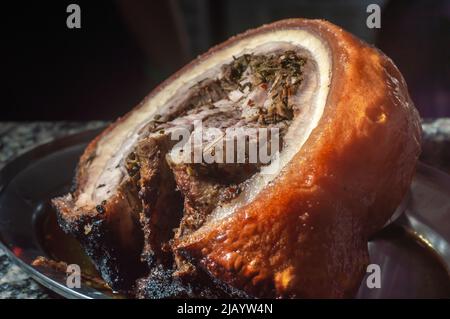 Arrosto tradizionale di Porchetta italiana, affettato e posto su un piatto di metallo. Foto Stock