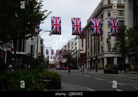 London City, Regno Unito -1 giugno 2022: Londra, Bond Street flag decoration. Bandiere britanniche appese sulle strade di Londra. Union Jack bandiera triangolare decorazione esterna Foto Stock