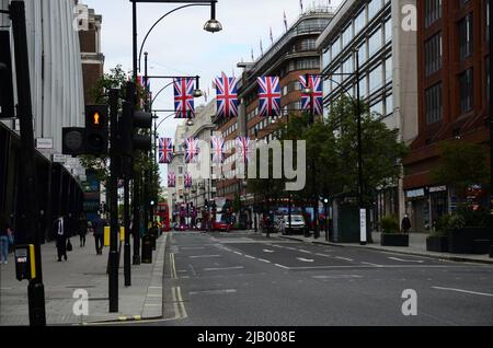 London City, Regno Unito -1 giugno 2022: Londra, Bond Street flag decoration. Bandiere britanniche appese sulle strade di Londra. Union Jack bandiera triangolare decorazione esterna Foto Stock