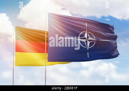 Cielo azzurro soleggiato e bandiere della nato e della germania Foto Stock