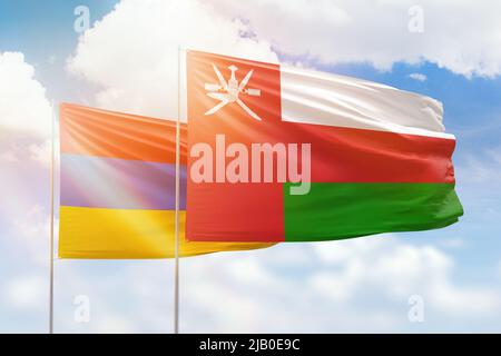 Cielo azzurro soleggiato e bandiere di oman e armenia Foto Stock