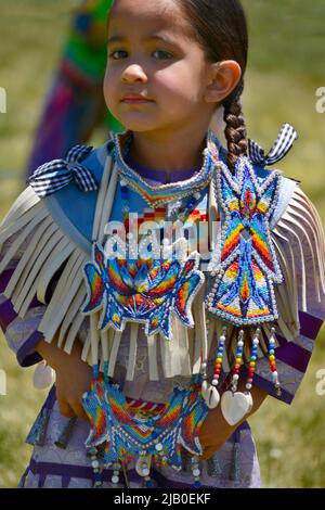 Una giovane bambina di nativi americani in regalia nativa assiste ad una cerimonia di laurea all'Institute of American Indian Arts di Santa Fe, New Mexico. Foto Stock