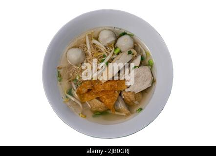 Tradizionale zuppa di spaghetti all'uovo con palla di pesce, polpette di gamberi, maiale, wonton fritto e germogli di fagioli in ciotola bianca isolato su sfondo bianco con clip Foto Stock