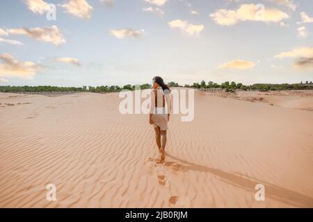 femmine asiatiche passeggiando dune di sabbia passi al tramonto a Mui NE, Vietnam Foto Stock