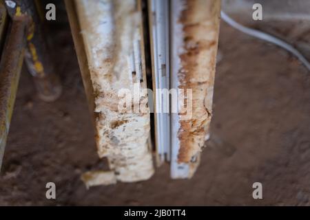 Materiale espanso di montaggio su finestre in plastica smontate in primo piano. Sostituzione di finestre obsolete Foto Stock