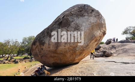 INDIA, TAMILNADU, MAHABALIPURAM, marzo 2022, turista al butterball di Krishna, un masso gigantesco di granito che riposa su un pendio corto Foto Stock