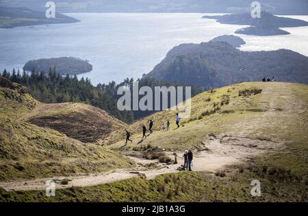 File photo datato 16/04/21 di persone che camminano sulla collina di Conic, sopra Loch Lomond a Balmaha, come una ditta di tecnologia sta sperando turisti durante il week-end di festa della banca di Giubileo gli darà i dati di cui ha bisogno per contribuire a prevenire il futuro overcrowding presso i visitatori hotspot. Foto Stock