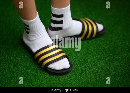 Dresda, Germania. 27th maggio 2022. ILLUSTRAZIONE - Un ragazzo indossa adilette e calze da tennis. (Posed scene) Credit: Robert Michael/dpa/Alamy Live News Foto Stock