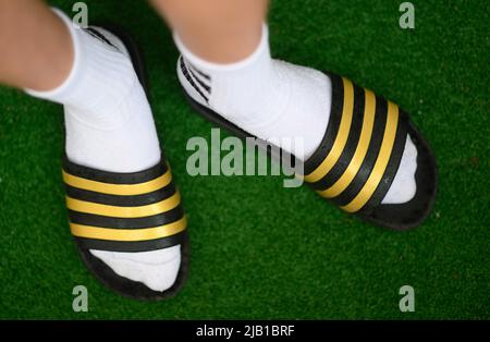 Dresda, Germania. 27th maggio 2022. ILLUSTRAZIONE - Un ragazzo indossa adilette e calze da tennis. (Posed scene) Credit: Robert Michael/dpa/Alamy Live News Foto Stock