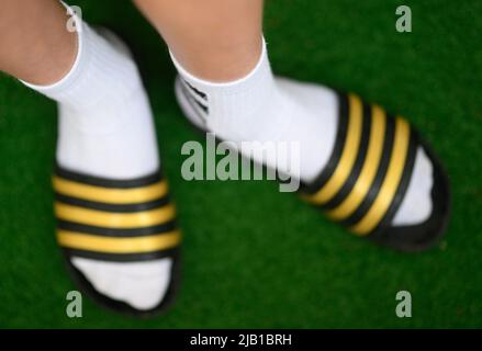 Dresda, Germania. 27th maggio 2022. ILLUSTRAZIONE - Un ragazzo indossa adilette e calze da tennis. (Posed scene) Credit: Robert Michael/dpa/Alamy Live News Foto Stock