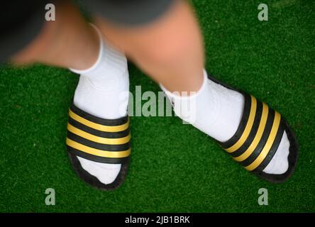 Dresda, Germania. 27th maggio 2022. ILLUSTRAZIONE - Un ragazzo indossa adilette e calze da tennis. (Posed scene) Credit: Robert Michael/dpa/Alamy Live News Foto Stock