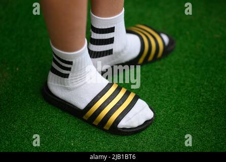 Dresda, Germania. 27th maggio 2022. ILLUSTRAZIONE - Un ragazzo indossa adilette e calze da tennis. (Posed scene) Credit: Robert Michael/dpa/Alamy Live News Foto Stock