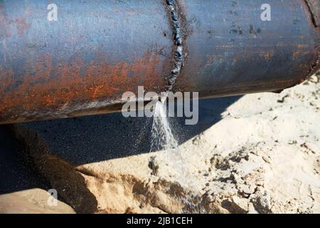 L'acqua si è rotta attraverso un tubo dell'acqua di ferro (rete dell'acqua bruciata). Mancanza di risparmio di acqua, perdita di acqua potabile Foto Stock