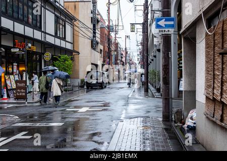 Kyoto, GIAPPONE - Apr 4 2021 : via Sanjo-dori in giornata di pioggia. Pedoni che utilizzano l'ombrello nell'immagine Foto Stock