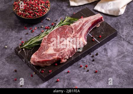 Braciole di vitello su sfondo scuro. Braciole di vitello crudo fresche con spezie. Primo piano Foto Stock