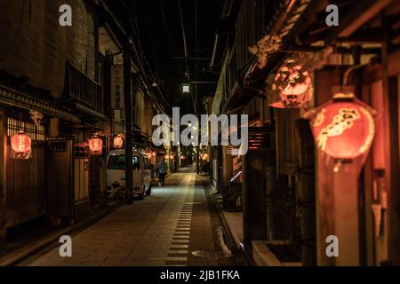 Paesaggio urbano di Miyagawa-cho, uno dei quartieri Hanamachi o geisha di Kyoto, di notte. Ochaya decorata con un ramo di Sakura e lanterna. Foto Stock