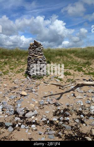 Un bel pilastro di rocce da spiaggia fatto per formare un pilastro conico a metà strada su una grande duna di sabbia in Merthyr Mawr dune di sabbia. Foto Stock