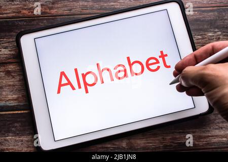 Kumamoto, GIAPPONE - Lug 30 2021 : Logo del conglomerato multinazionale Alphabet inc. (Una ristrutturazione di Google il 2 2015 ottobre) su tablet. Uomo che tiene la penna Foto Stock