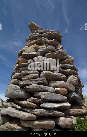 Un bel pilastro di rocce da spiaggia fatto per formare un pilastro conico a metà strada su una grande duna di sabbia in Merthyr Mawr dune di sabbia. Foto Stock