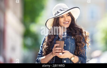 Ritratto d'estate una giovane donna felice con il caffè nelle sue mani. Foto Stock