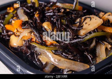 Primo piano insalata giapponese simmered Hijiki (Sargassum fusiforme, syn. Hizikia fusiformis), venduto dal supermercato locale giapponese. Hijiki è un vegeto di mare marrone Foto Stock