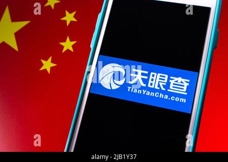 Kumamoto, GIAPPONE - Nov 15 2021 : Closeup logo di TianYanCha.com (Tian Yan Cha) su iPhone su bandiera cinese. Foto Stock