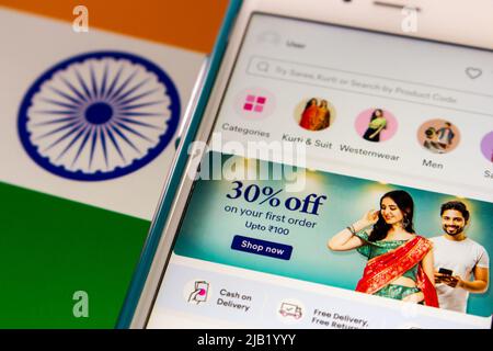 Screen of Indian social e-commerce Meesho app, specializzata nella fornitura di piattaforma online per le piccole imprese di vendere prodotti, su iPhone su bandiera indiana Foto Stock