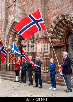 I registi di bandiera tengono le bandiere di Norvegia e Scozia fuori dalla cattedrale di St Magnus per celebrare il Norway Day nel centro di Kirkwall, Isole Orkney, SCO. Foto Stock