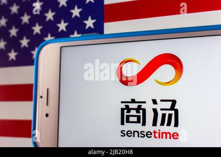 Kumamoto, GIAPPONE - Dicembre 14 2021 : il logo di SenseTime, una società leader di software per l'intelligenza artificiale di Hong Kong, su iPhone sulla bandiera degli Stati Uniti Foto Stock