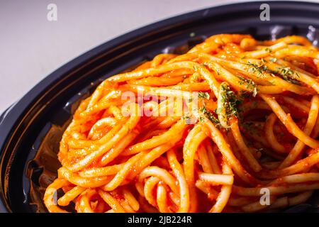 Gli spaghetti giapponesi napaporitani da asporto in un vassoio di cibi. Il napaporitano (o napoletano) è un piatto di pasta giapponese. Si compone di spaghetti, ketchup al pomodoro Foto Stock