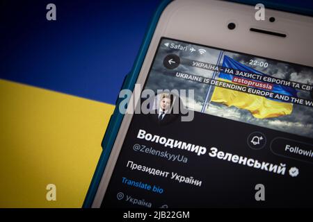 Twitter account di Volodymyr Zelenskyy, il 6th e presidente in carica dell'Ucraina (ex attore e comico), su iPhone su una bandiera Ucraina di umore scuro Foto Stock