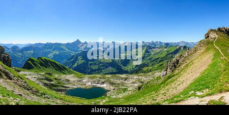 Splendida vista sulle Alpi di Allgäu in una mattinata estiva con Laufbichlsee in primo piano Foto Stock