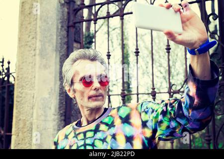 spaventoso uomo sanguinoso zombie prende un selfie in un cimitero Foto Stock