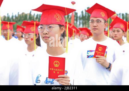 ZHANGYE, CINA - 2 GIUGNO 2022 - più di 1.470 18 anni anziani della scuola superiore ricevono la Costituzione della Repubblica popolare Cinese e adulti g Foto Stock