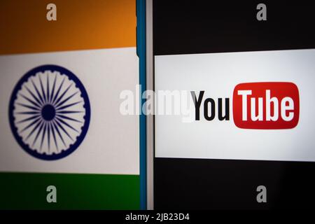 Kumamoto, GIAPPONE - Feb 22 2022 : l'immagine concettuale del logo di YouTube su uno schermo iPhone sullo sfondo della bandiera nazionale indiana in condizioni di oscurità. Foto Stock