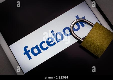 Kumamoto, GIAPPONE - Feb 22 2022 : logo Facebook con grande lucchetto sul tablet di colore scuro. Sicurezza digitale nel concetto di account di social media. Foto Stock