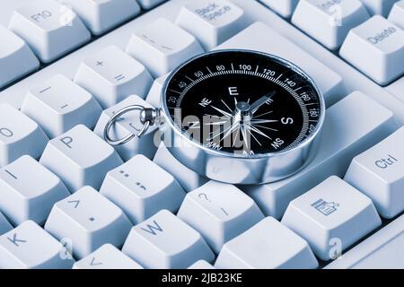 Il concetto di Internet Navigator . Vecchia bussola metallica sulla tastiera del computer. Navigazione attraverso Internet. Foto Stock
